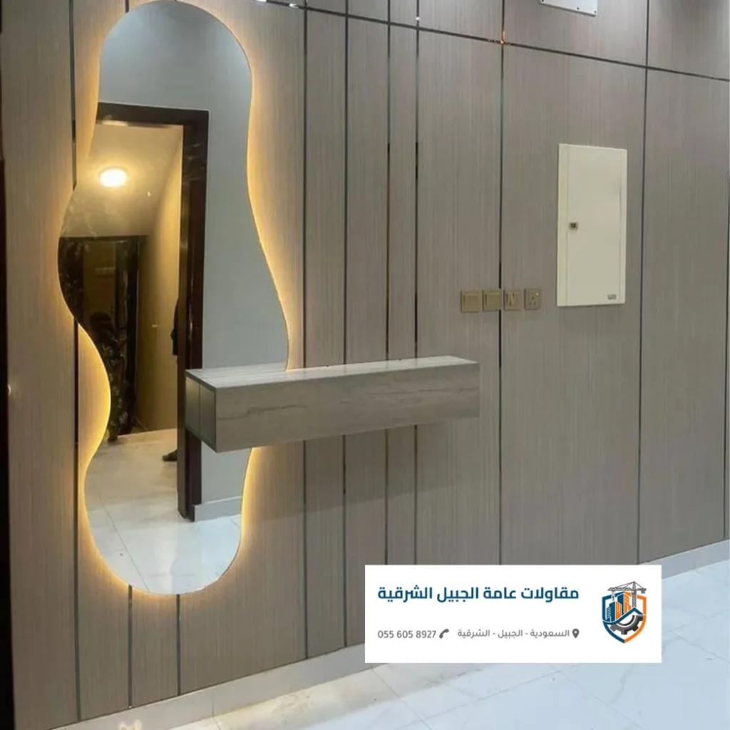الرئيسية مدخل منزل في الجبيل يجمع بين الرخام والإضاءة الأرضية والديكورات الخشبية.