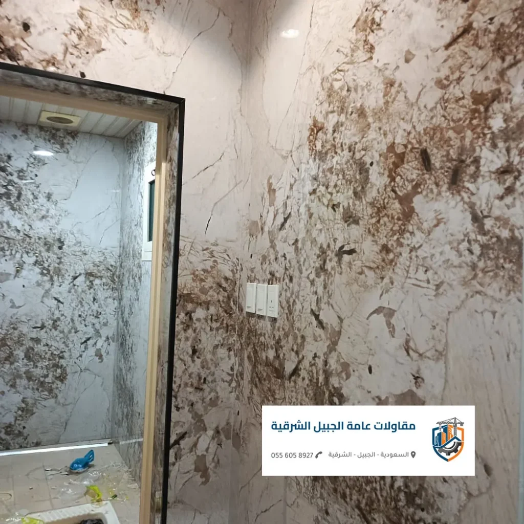 شرائح ستانلس ستيل ذهبي مدمجة بين ألواح بديل الرخام في مدخل فيلا بالجبيل.