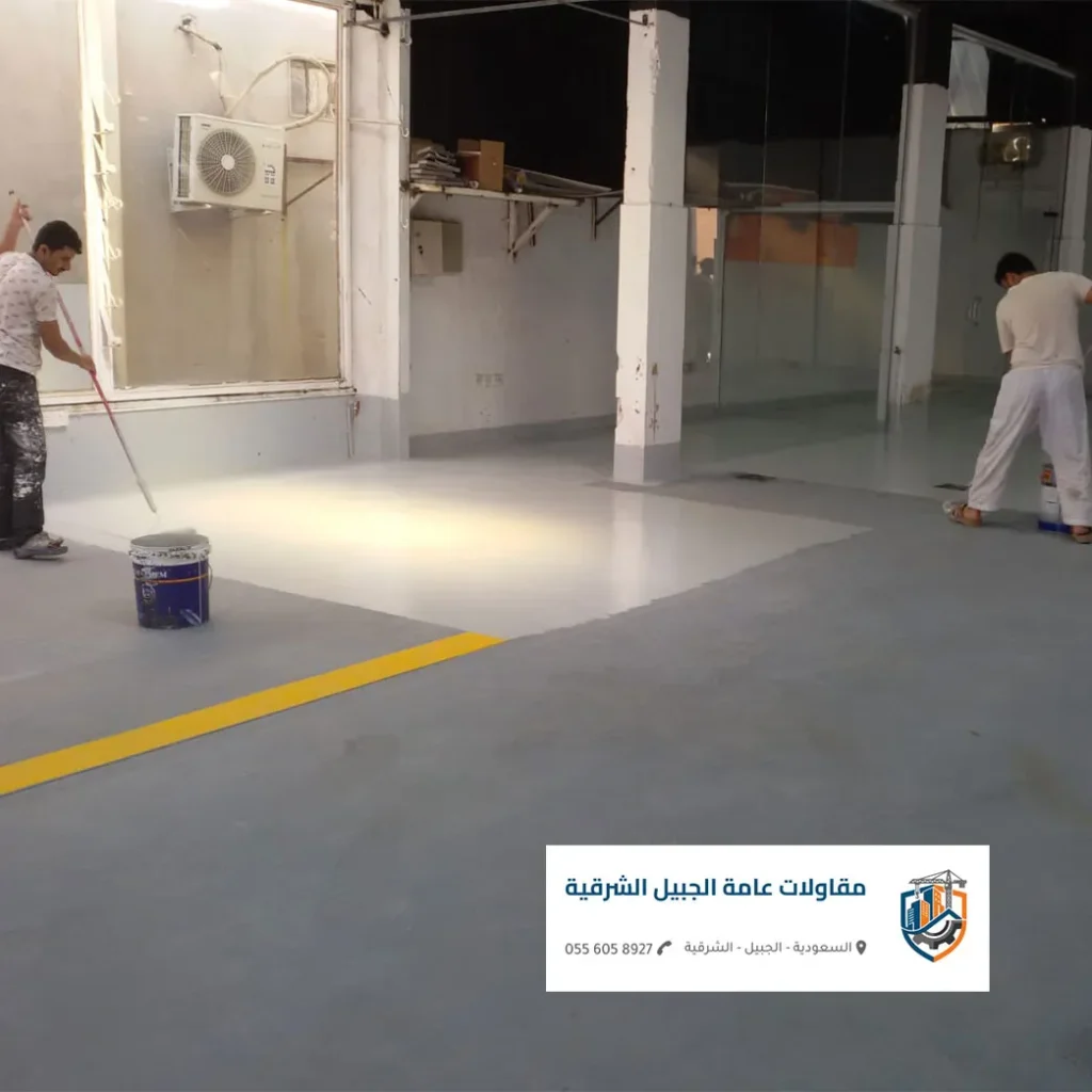 تطبيق دهان ابكسي الجبيل رمادي اللون لأرضية مستودع خرساني كبير.